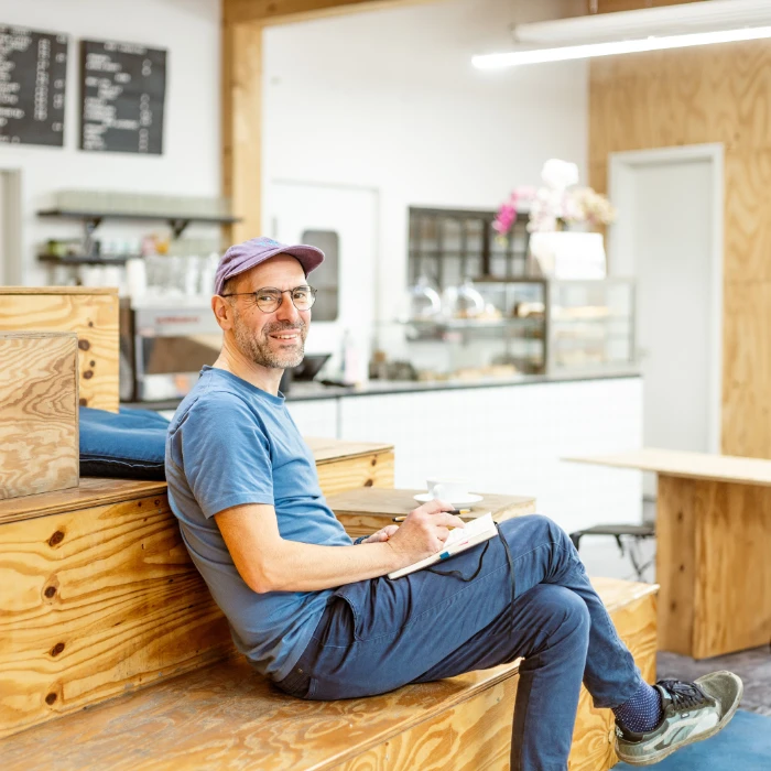 Thomas Binroth sitzt entspannt in einem Berliner Café mit Notizbuch